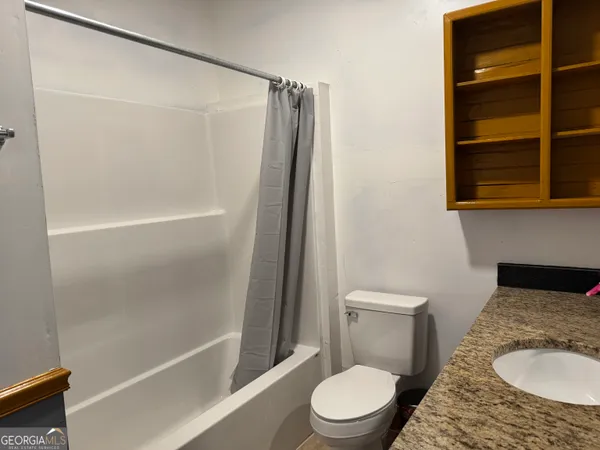a white toilet sitting next to a bath tub