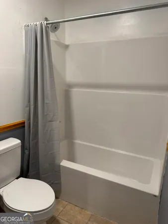 a white toilet sitting next to a bath tub