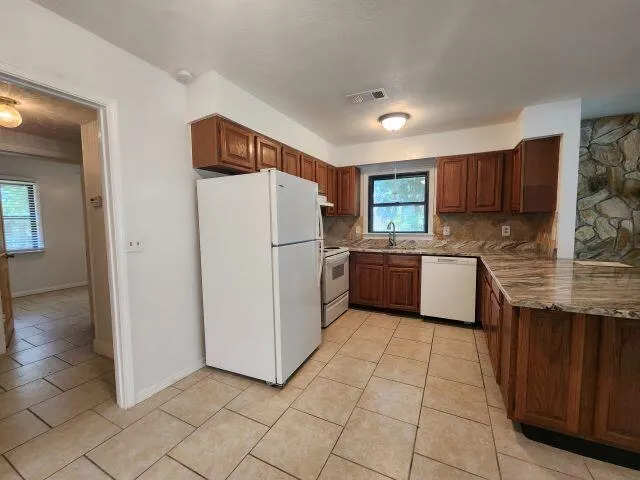 a kitchen with a refrigerator sink and cabinets