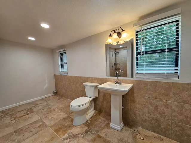 a bathroom with a sink toilet and window