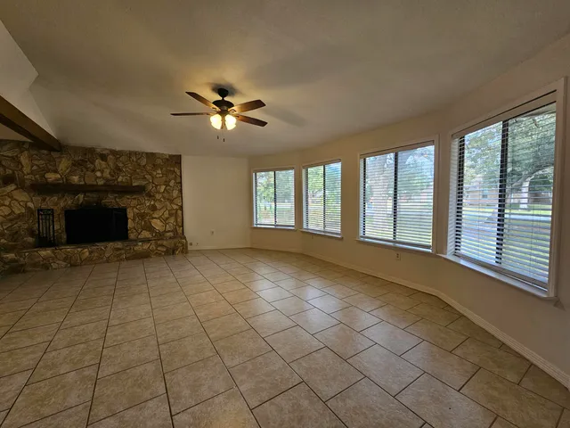 a view of n empty room with fireplace and fan