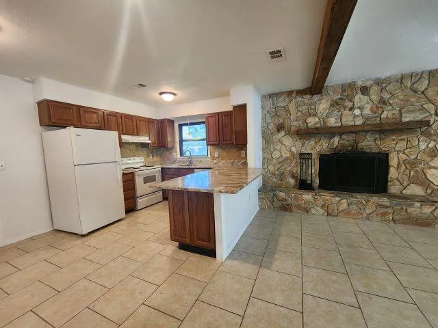 a kitchen with a refrigerator and a stove top oven