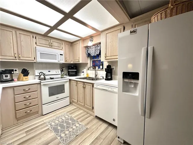 a kitchen with white cabinets and white appliances