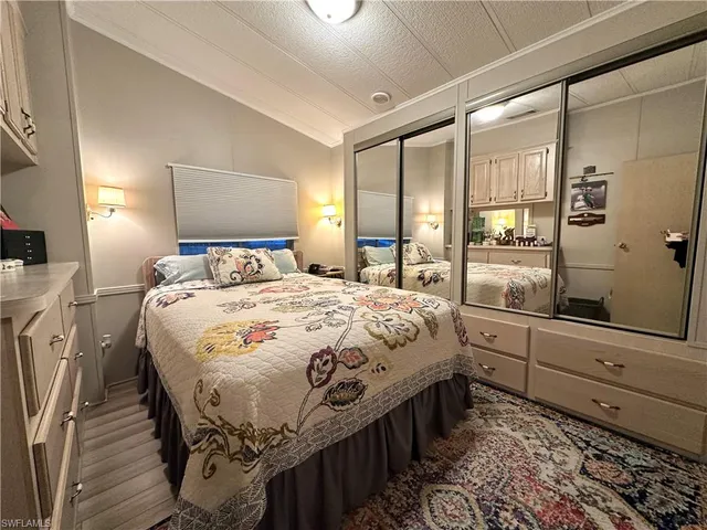 a bedroom with a bed and closet with wooden floor