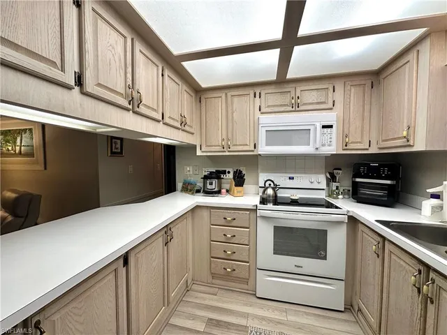 a kitchen with stainless steel appliances granite countertop white cabinets and window