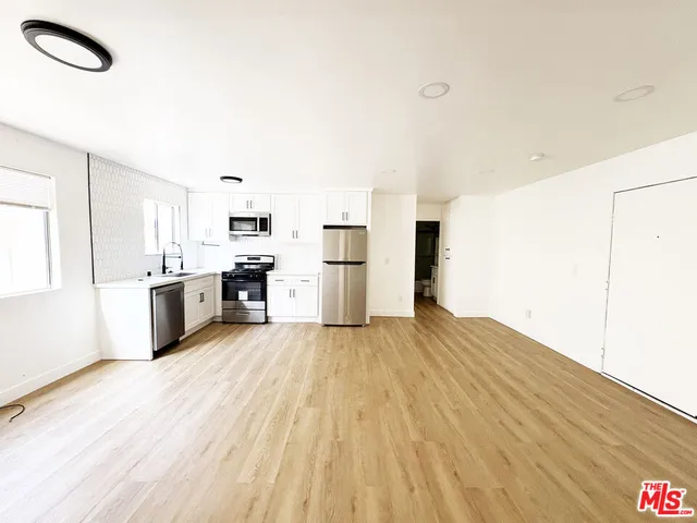 a kitchen with stainless steel appliances a refrigerator and a stove top oven