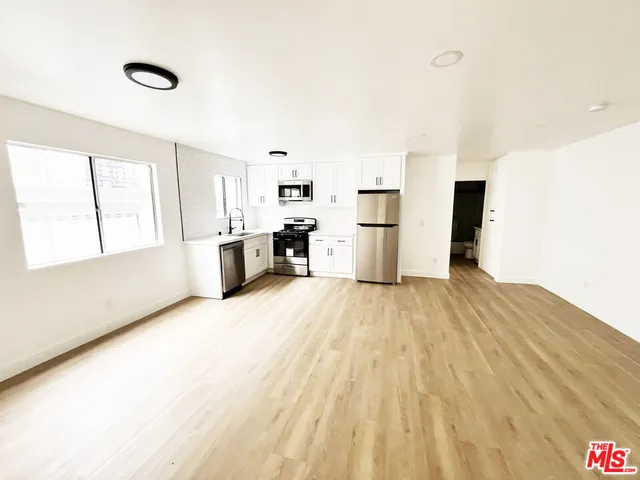 a view of empty room with wooden floor and window