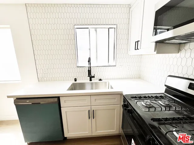 a kitchen with a sink stove and cabinets