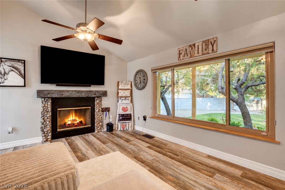 6460 Racel Street Las Vegas, NV 89131 - Photo 33 of 59 A stone-accented fireplace and a wide picture window highlight this vaulted living space.