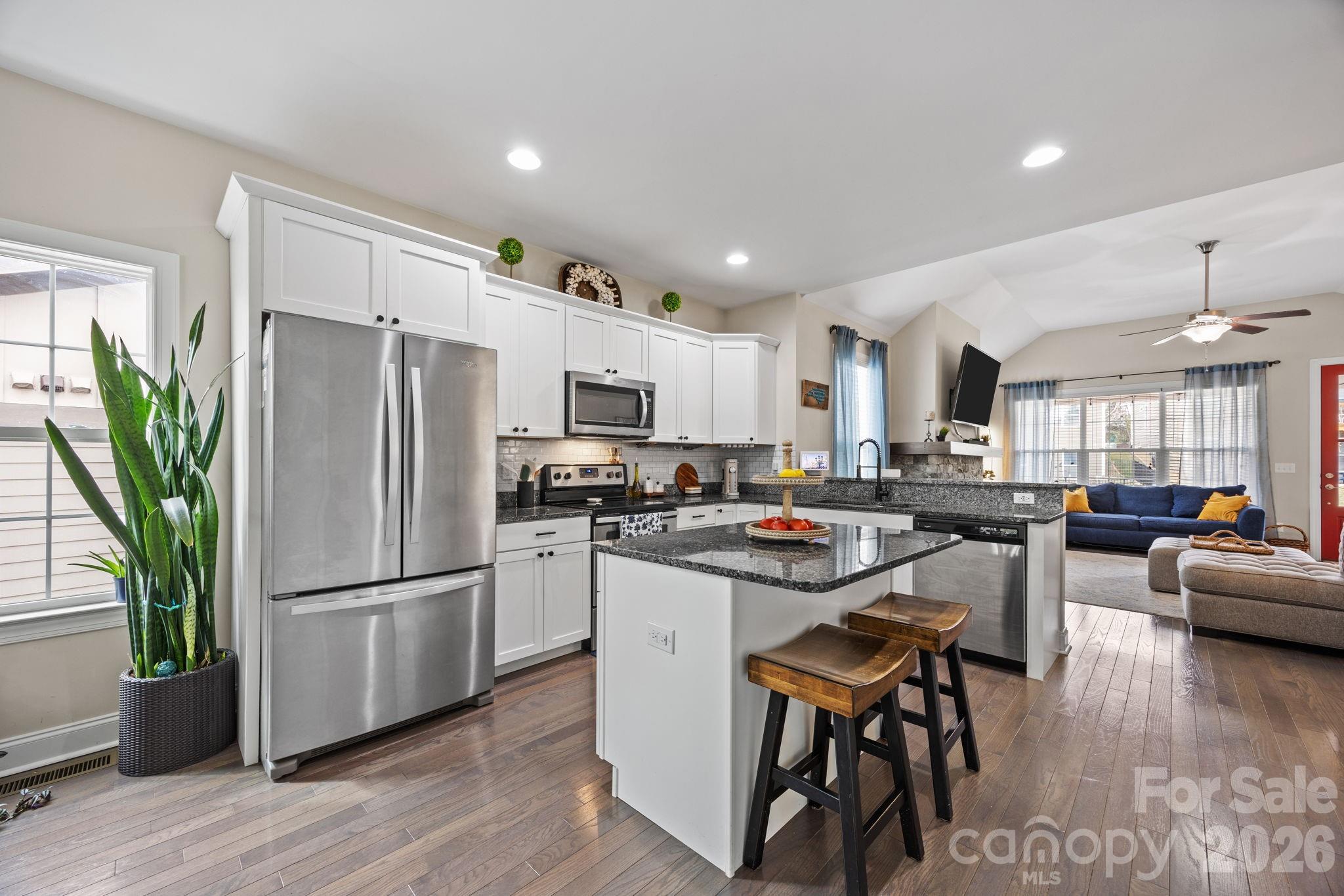 3 Dreambird Road Leicester, NC 28748 - Photo 19 of 48 a kitchen with stainless steel appliances granite countertop a refrigerator a stove a sink dishwasher a oven a dining table and chairs with wooden floor