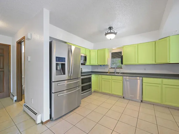 a kitchen with granite countertop a stove top oven cabinets and a refrigerator