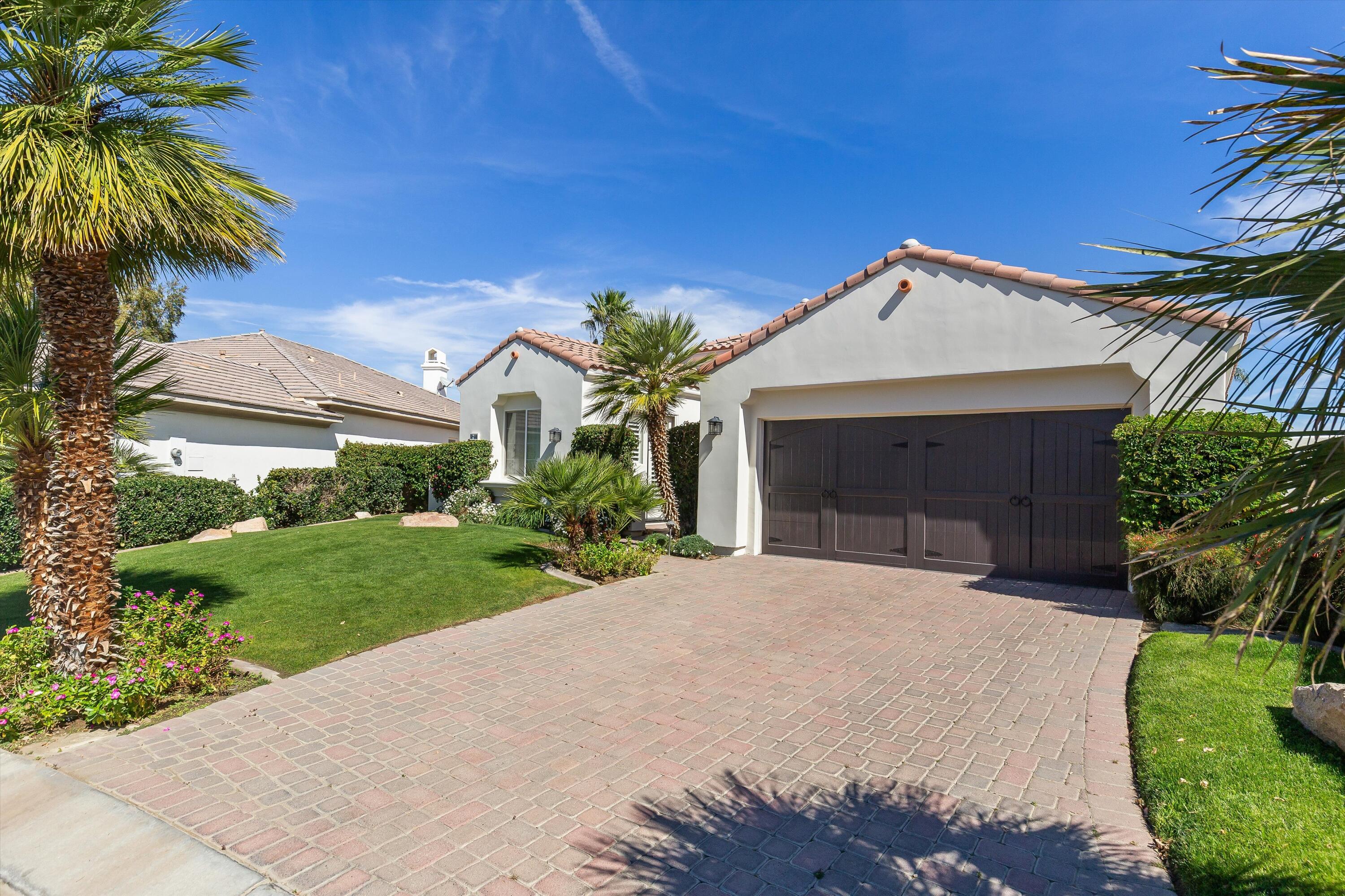 80460 Torreon Way La Quinta, CA 92253 - Photo 8 of 32 a front view of a house with a yard and garage