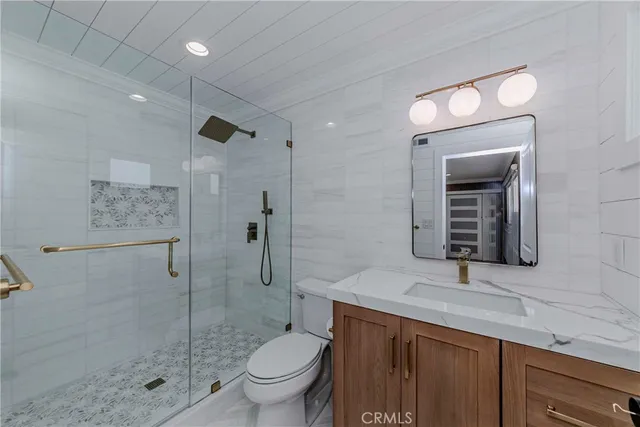 a bathroom with a sink a toilet and shower