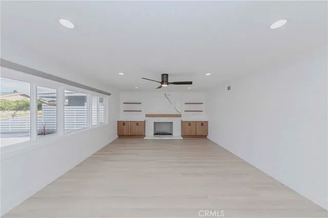 an empty room with windows and ceiling fan