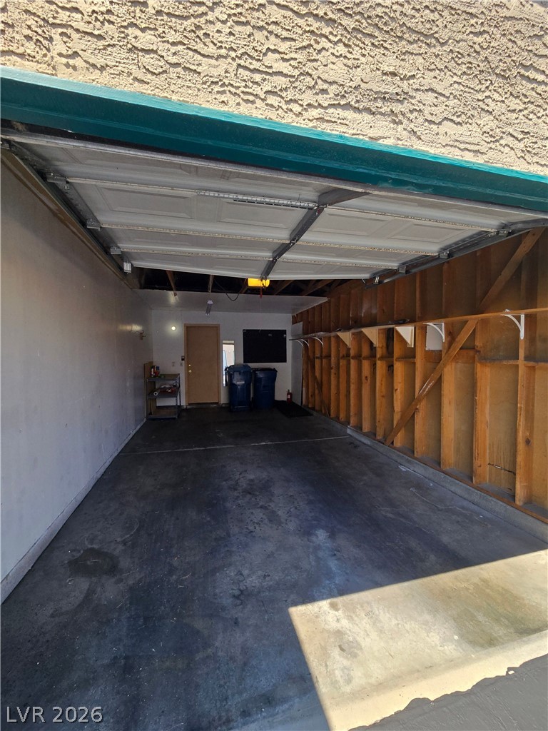 6750 Del Rey Avenue, Unit 133 Las Vegas, NV 89146 - Photo 32 of 34 Functional garage space with exposed wooden framing and a durable concrete floor.