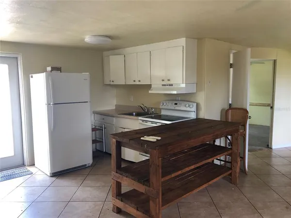 a kitchen with a stove a refrigerator and a cabinets