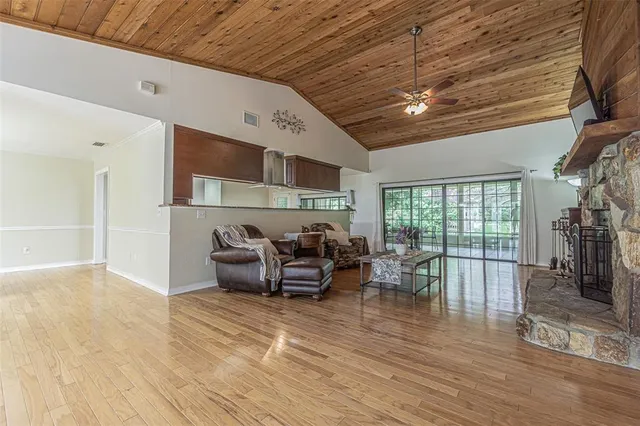 a living room with furniture large window and wooden floor