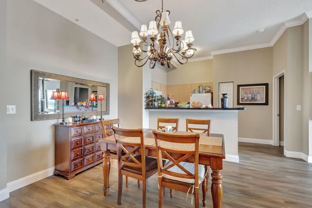 a dining room filled chandelier and wooden floor