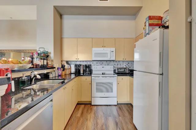 a kitchen with white cabinets and white appliances