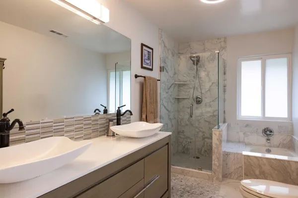 a bathroom with a sink a toilet and shower