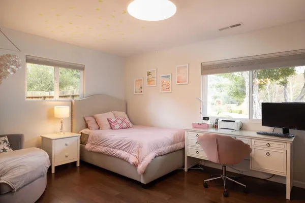 a bedroom with a bed window and a desk