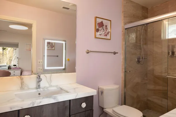 a bathroom with a sink a toilet and shower