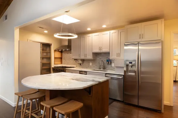 a kitchen with stainless steel appliances a sink stove and refrigerator