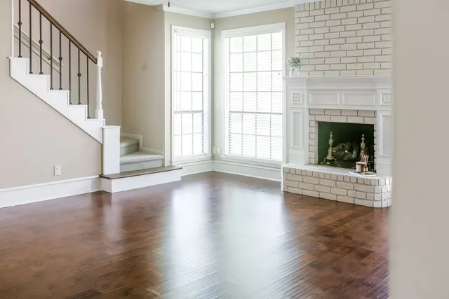 a view of empty room with wooden floor and fireplace