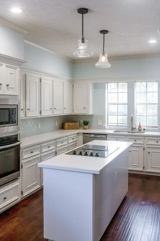a kitchen with granite countertop white cabinets and a sink