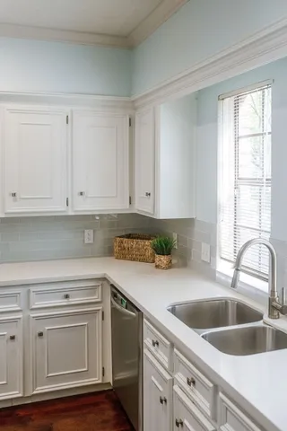 an empty room with wooden floor cabinet and windows