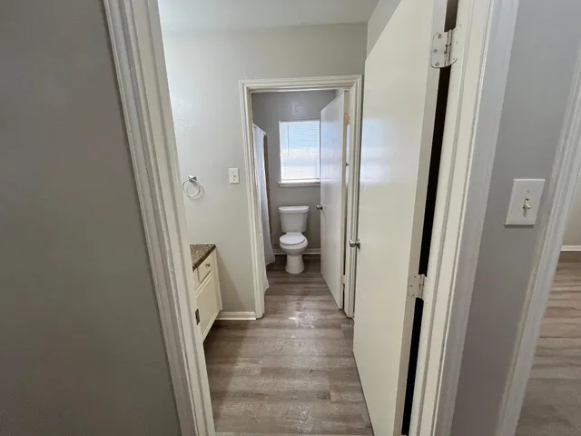 a view of a hallway with wooden floor and a carpet