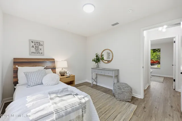 a bedroom with a bed and wooden floor
