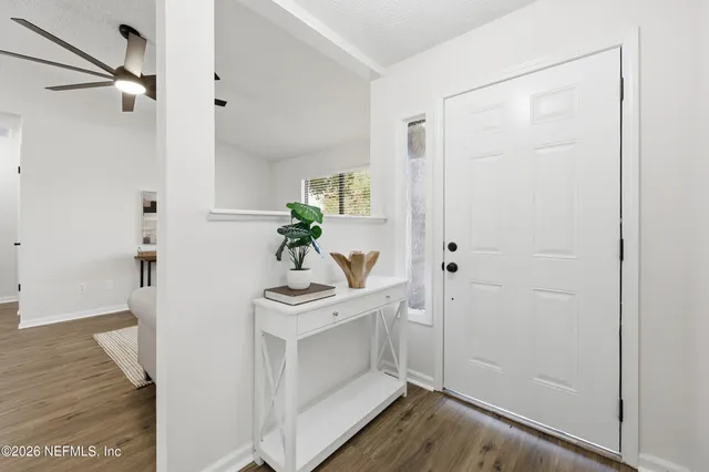 a hallway with white cabinets and wooden floor