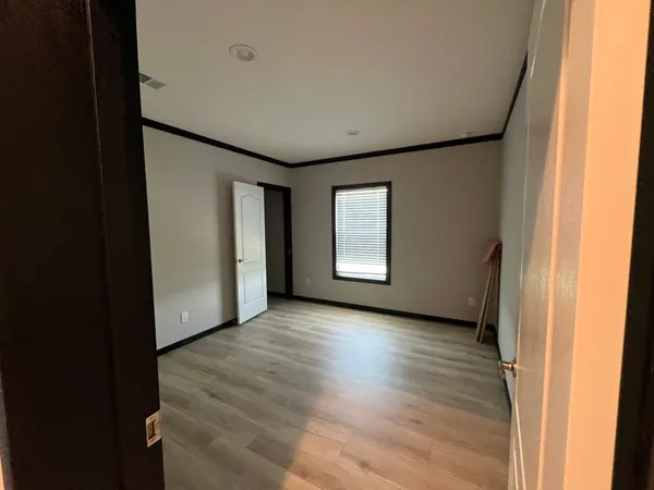 a view of a livingroom with wooden floor and a window