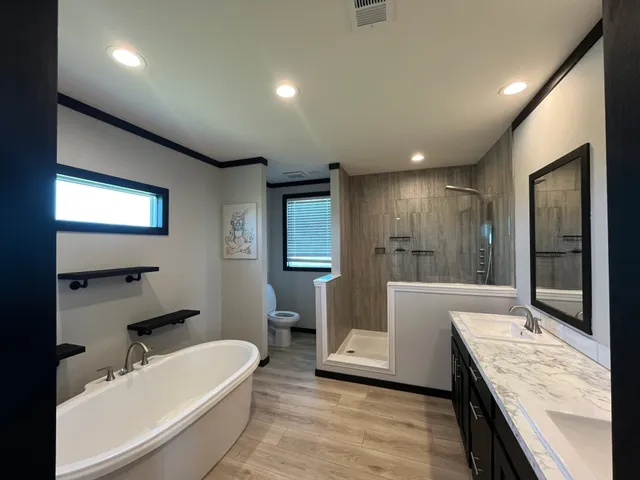 a large bathroom with a granite countertop tub sink a mirror and a shower