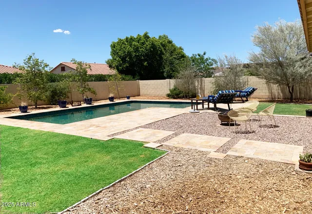 a view of a swimming pool with a patio and a garden