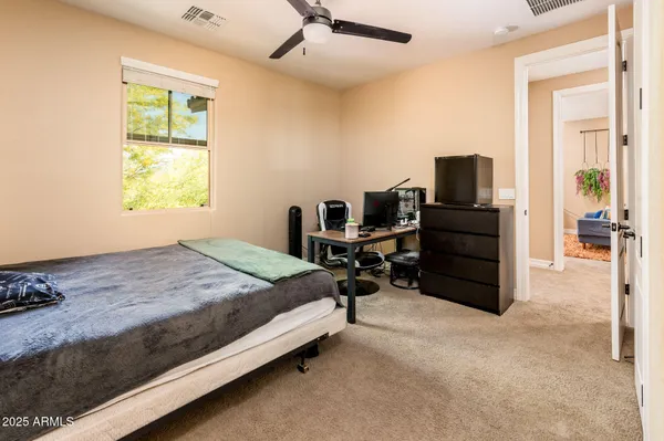 a bedroom with a bed workspace and a window
