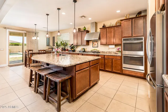 a kitchen with stainless steel appliances granite countertop a stove a sink and a refrigerator