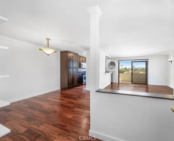 a view of a kitchen with wooden floor and a large window