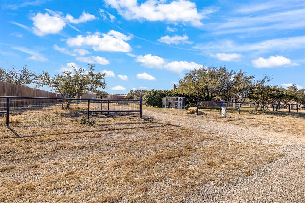 116 Miramar Circle Weatherford, TX 76085 - Photo 32 of 37 View of yard featuring a view of gravel driveway with pastoral area and trees that provide shade to pool area.
