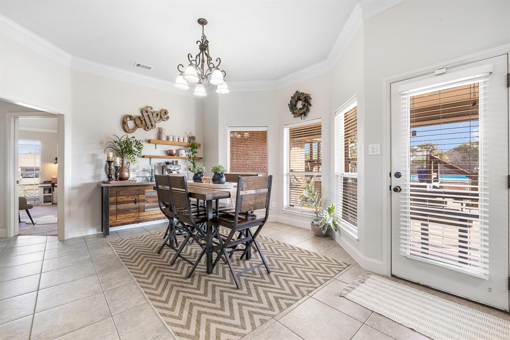 116 Miramar Circle Weatherford, TX 76085 - Photo 7 of 37 Dining room featuring ornamental molding, lots of natural light, a chandelier, and light ceramic tile floors, room for a coffee bar and doggie door in corner