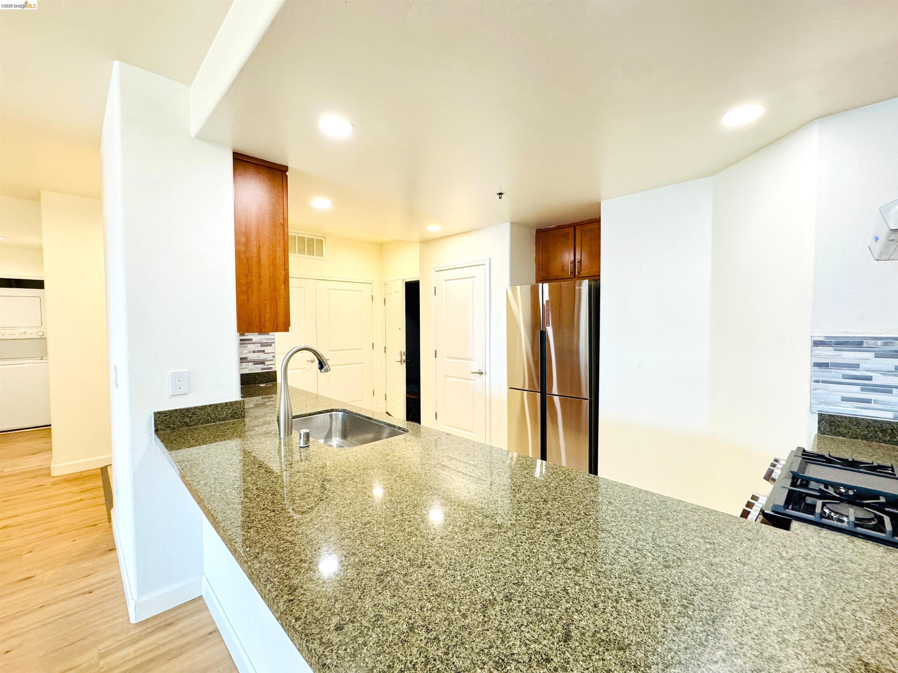 423 7th Street, Unit 303 Oakland, CA 94607 - Photo 12 of 19 a kitchen with stainless steel appliances granite countertop a sink and a refrigerator