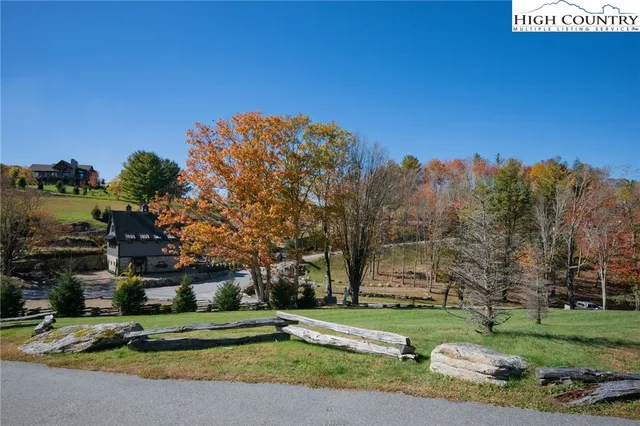 a view of a house with a big yard and large trees