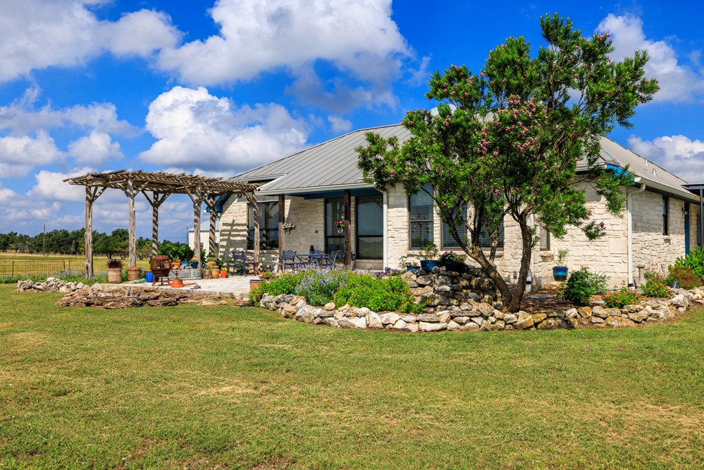 564 Gypsum Mine Road Fredericksburg, TX 78624 - Photo 13 of 20 a view of a chair and tables in the patio next to a yard