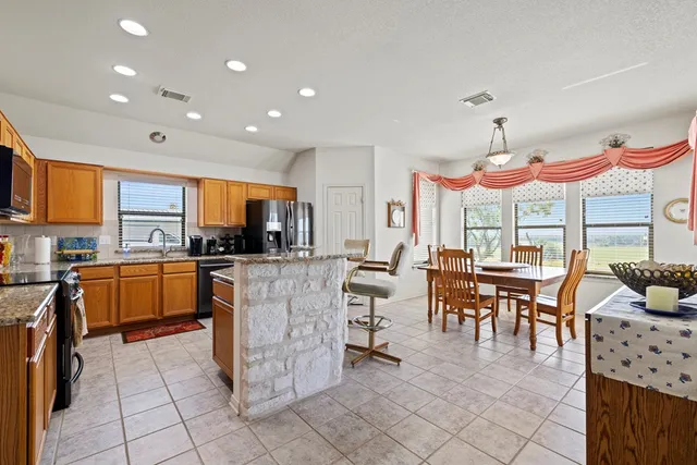 a large kitchen with lots of counter and chairs