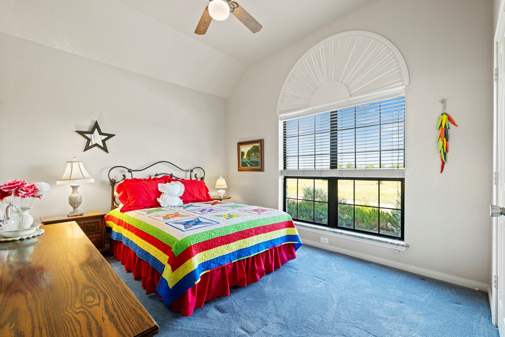 564 Gypsum Mine Road Fredericksburg, TX 78624 - Photo 8 of 20 a bedroom with a bed and a chandelier