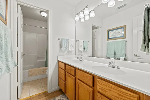 a bathroom with double vanity sinks and a shower