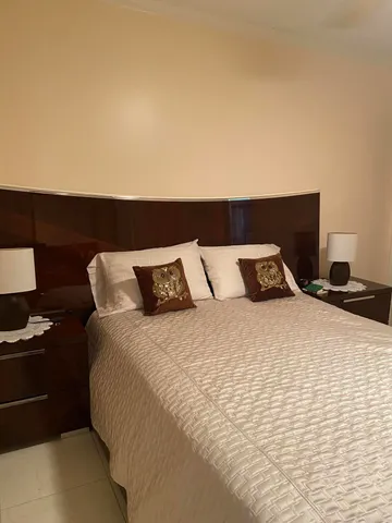 a large bed sitting in a bedroom next to a lamp