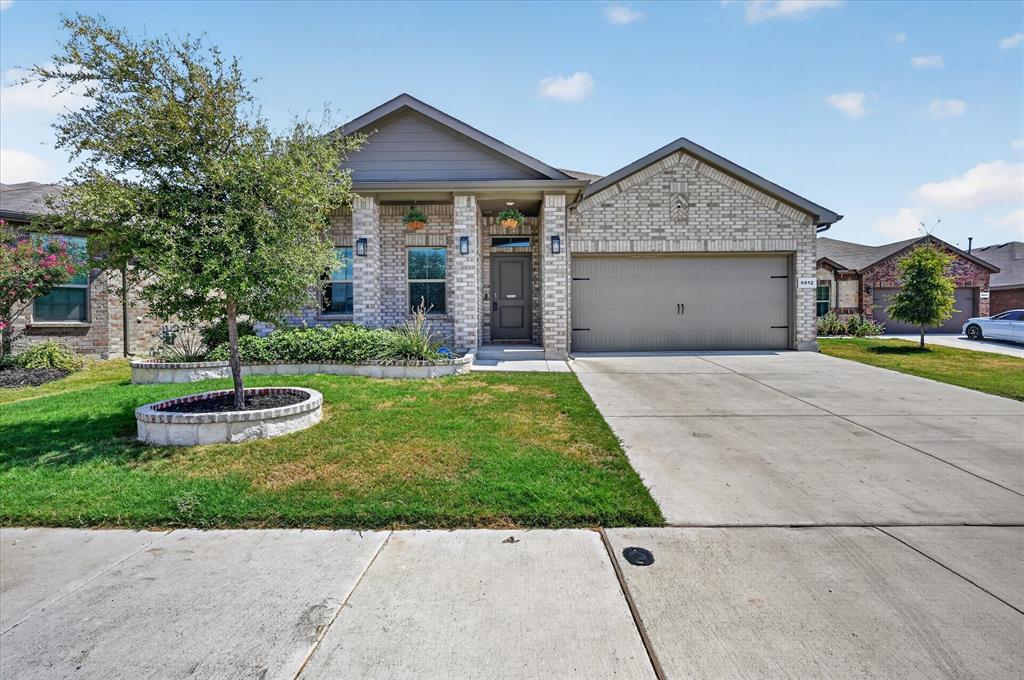 8812 Russano Road Fort Worth, TX 76131 - Photo 5 of 40 Brick and siding exterior featuring a two-car garage, concrete driveway, and front yard landscaping