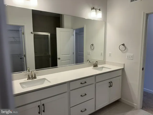 a bathroom with a double vanity sink and mirror